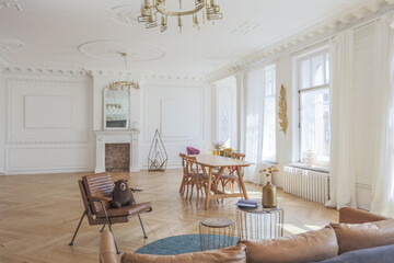 luxury interior of a spacious apartment in an old 19th century historical house with modern furniture. high ceiling and walls are decorated with stucco