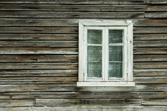 An old and rustic wooden window with glass in Estonian countryside, Northern Europe. 