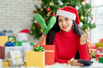 Pretty woman with Christmas costume lie on floor also look at camera with smiling, she also show mini heart symbol.