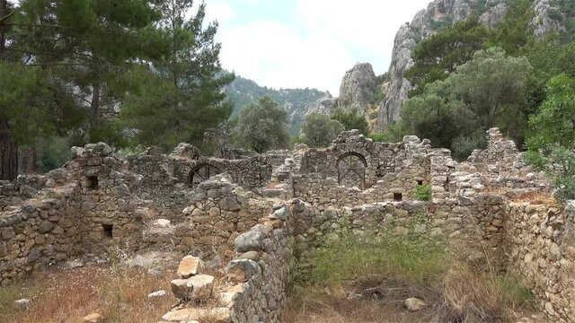 Olimpos, Antalya, Turkey - 29th of May 2021: 4K Remains of ruined houses of Olimpos city at the mountains
