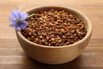 Bowl of chicory granules with flower on wooden table