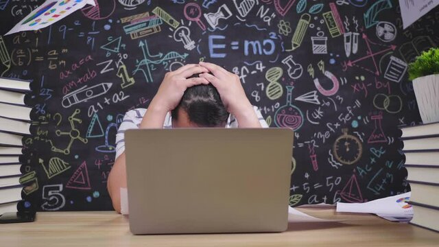 Close up of Tired asian teacher glasses man throwing paper while sitting at desk in classroom. Male teacher touching head and taking off glasses. Education concept.