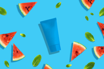Creative beauty fashion concept photo of sliced watermelon fruit with cosmetic recyclable bottle lotion creamon blue background. 