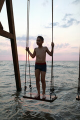Kid standing on swing in Sea of Azov