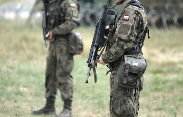 Soldiers of Poland with assault rifle and flag of Poland on military uniform. Polish soldiers with assault rifle.