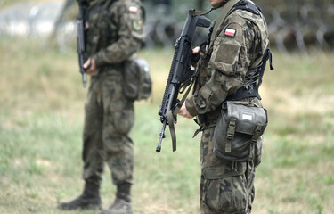 Soldiers of Poland with assault rifle and flag of Poland on military uniform. Polish soldiers with...