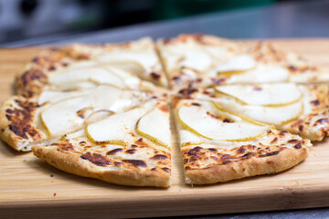 pizza with pear on a wooden board