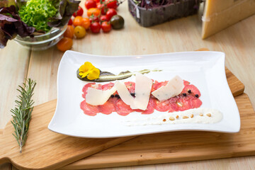 carpaccio appetizer on wooden table with vegetables