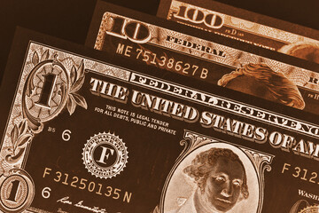 US banknotes of 1, 10 and 100 dollars close up. Dark brown inverted and tinted illustration. Taxes, Social Security and pensions in the USA. Macro