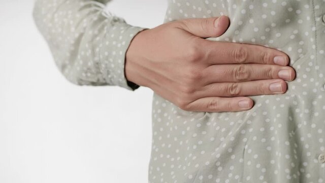 Pain in right side, pain in liver. Female hand touches her right side of abdomen. Close-up and slow motion