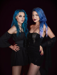 Two blue-haired informal (rock) girls in black clothes. Portrait of 2 cute women. Dark beauty