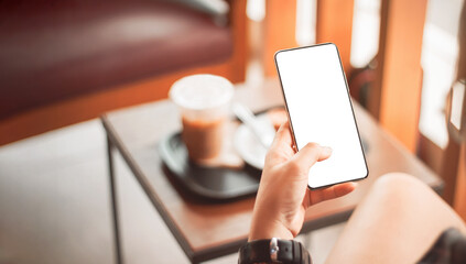 Young woman using a smart phone. Mockup image blank white screen cell phone. Social media concept. Background empty space for advertising text.