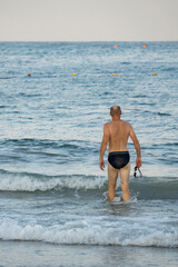 A Man Going for a Swim in the Ocean