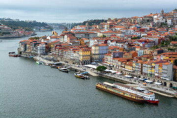 Fototapeta na wymiar Porto, Portugal, October 31,2020. View on colorful old houses on hill in old part of city and embankment of Douro river in rainy day