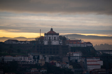 Fototapeta na wymiar Panoramic view on Douro river and old part of Porto city in Portugal at cloudy sunrise