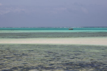 Endless turquoise ocean with stripes of white sand and karals