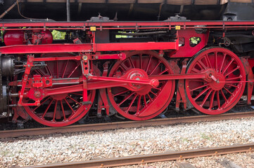 Fototapeta na wymiar Red wheels of an old historic steam train with mechanics