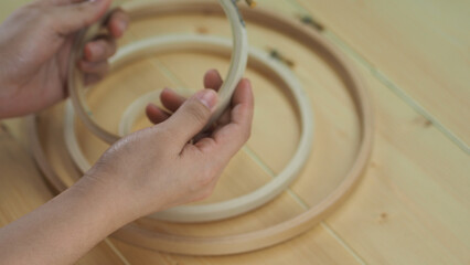 Embroider sewing by woman hand. Craft work and female hands. Handicraft work by thread needle sew knit. Wood frame embroidery hoop. Needlework handicraft crafting quarantine leisure concept. © gnepphoto