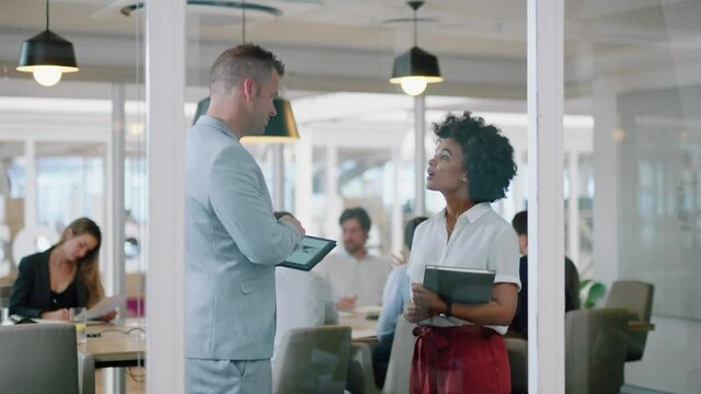 businessman chatting to intern woman discussing project data on tablet briefing personal assistant sharing development strategy in modern office 4k