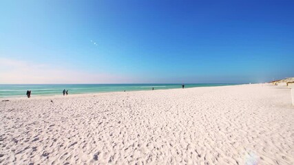 Gulf of mexico emerald coast sea ocean water on sunny winter day Seaside, Florida beach on panhandle with people sunbathing along white quartz sand 
