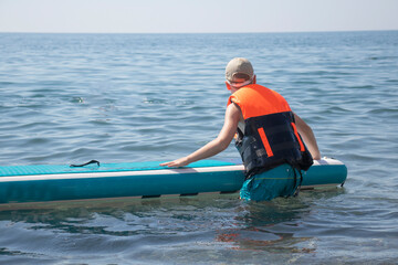 Obraz premium boy sailing on Sup board in the sea