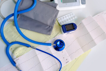 stethoscope, medical device pulse oximeter for measuring oxygen in the blood on a white table,...