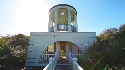 Point of view pov handheld walking to pavilion gazebo by sea beach at Gulf of Mexico at Seaside, Florida with new urbanism pastel blue architecture