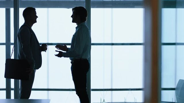 silhouette business people shaking hands meeting in corporate office for partnership deal greeting client with handshake welcoming opportunity in office 4k