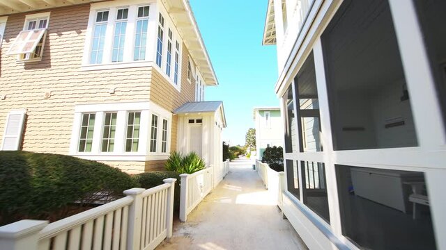 Seaside, Florida USA white beach wood architecture and path way sand sidewalk by vacation real estate houses in new urbanist style on sunny winter day