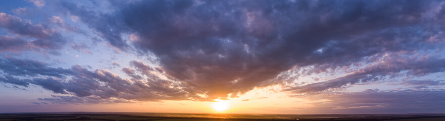 Obraz premium Panorama of a beautiful purple sunset with clouds.