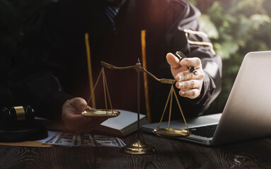 Business and lawyers discussing contract papers with brass scale on desk in office. Law, legal services, advice, justice and law concept picture with film grain effect