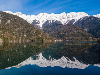 Obraz premium Mountain glacial lake Ritsa in Abkhazia at winter season. Rocky mountain peaks covered with snow. Mountain landscape. Abkhazia.