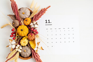 Flat lay with calendar for november with autumn table decoration.  Floral interior decor for fall...