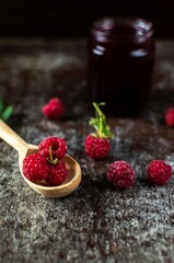 Raspberry jam with raspberries in a spoon