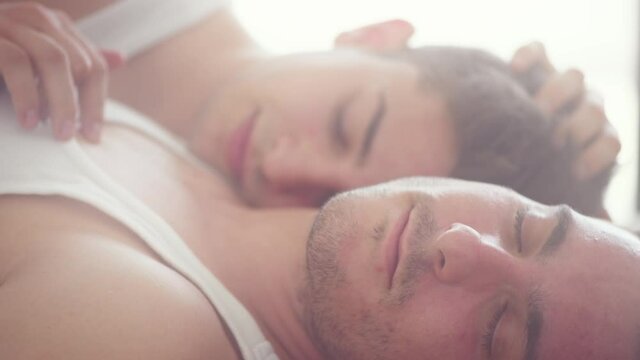 Romantic gay couple lying in bed, kissing and hugging. Happy Men Couple in love. LGBT 