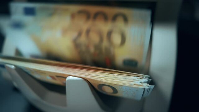 Money counting machine. 200 euro banknotes on a counter. Modern bank equipment is processing euros currency. Automatic operations of cash. Banking or commercial activity and investment concept