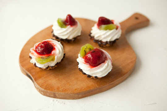 cupcakes with cottage cheese on vintage tray-tasty muffin with strawberry and kiwi on wooden plate