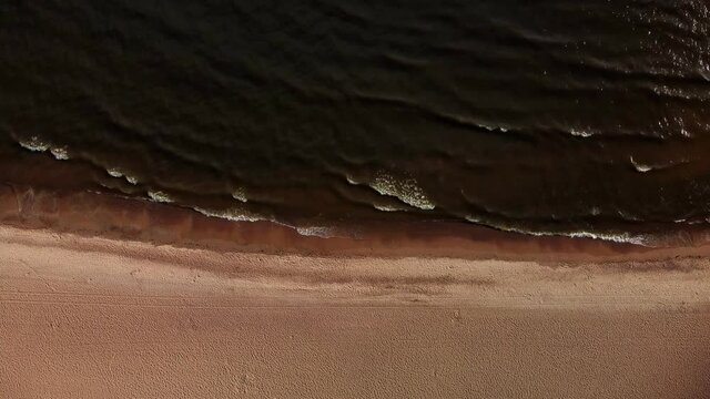 top view of the beach and the sea in brown tones. aerial view of a secluded empty autumn beach. a gloomy, sad, sepia seascape. background for designers, free space. one-color dull futage with water