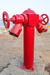 Fototapeta na wymiar Close-up of a red fire hydrant in the desert. Sand and sea. Beach.