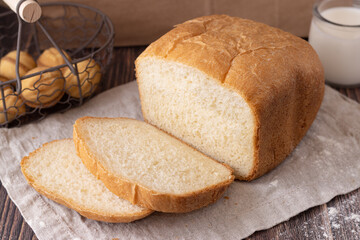 a loaf of wheat bread, cut into slices on a linen towel
