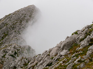 View of rocky mountain slopes in the dense fog