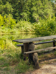 Fototapeta na wymiar old table and bench for travelers on the river bank