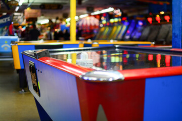 Air hockey arcade game with striker in focus and blurred background - obrazy, fototapety, plakaty