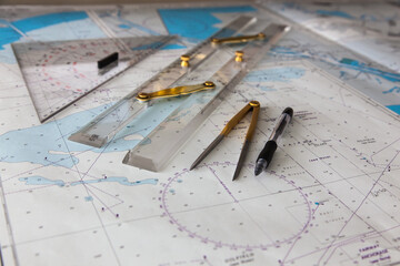 Fototapeta na wymiar Maps of the ship for plotting. Plotter, divider, ruler and pen. Close-up.