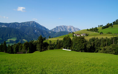 Fototapeta na wymiar a scenic view of a little village and the green meadows in the Austrian Alps of the Schladming-Dachstein region (Steiermark or Styria, Austria)