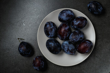 Fresh plums. Fruits. On a dark background. Copy space.
