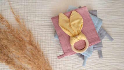 Baby textile wraps with wooden eco toy and pampas grass on light yellow background. Set of the...