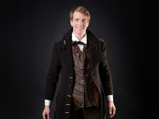character of the steampunk story, a young attractive man in an elegant long coat