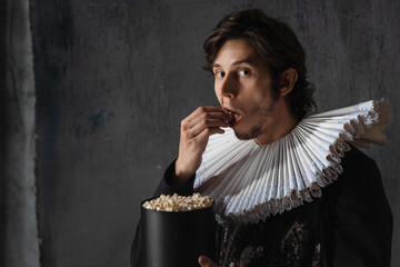 Cinema spectator of the Renaissance, a man in a medieval collar eats popcorn,