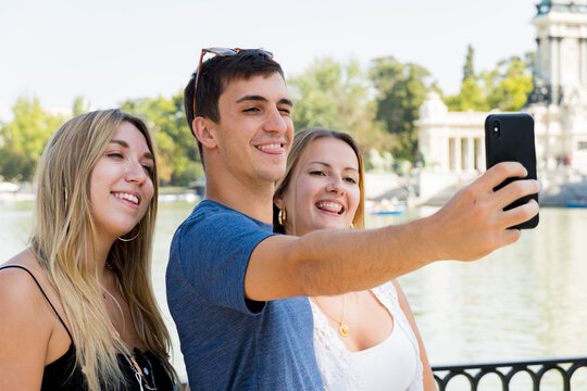 Young caucasian friends sticking out their tongues taking a selfie with the phone